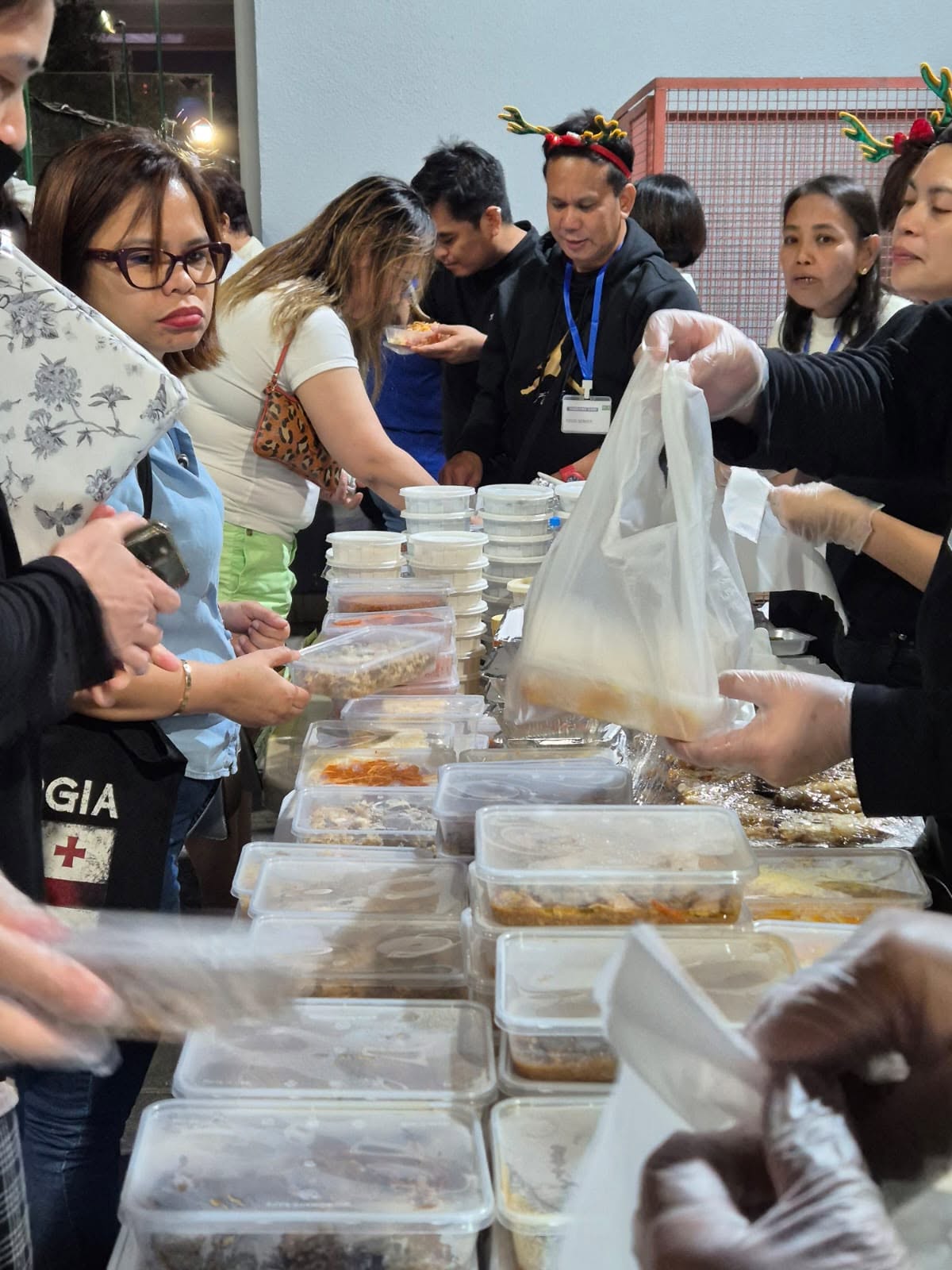 Volunteers handing out bagged meals to families