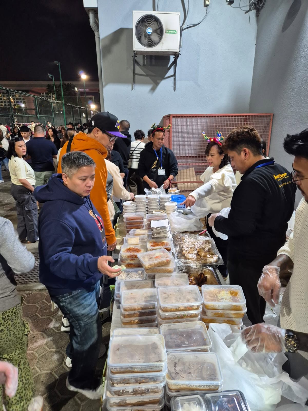 Sweet Pepper staff in branded uniforms distributing food outdoors
