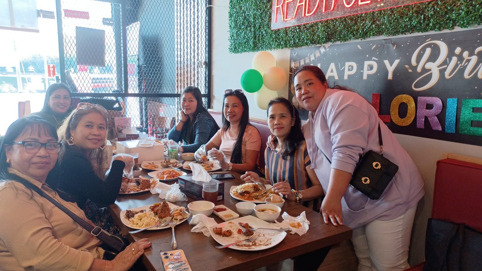 Group of friends sharing a birthday buffet feast in the booth