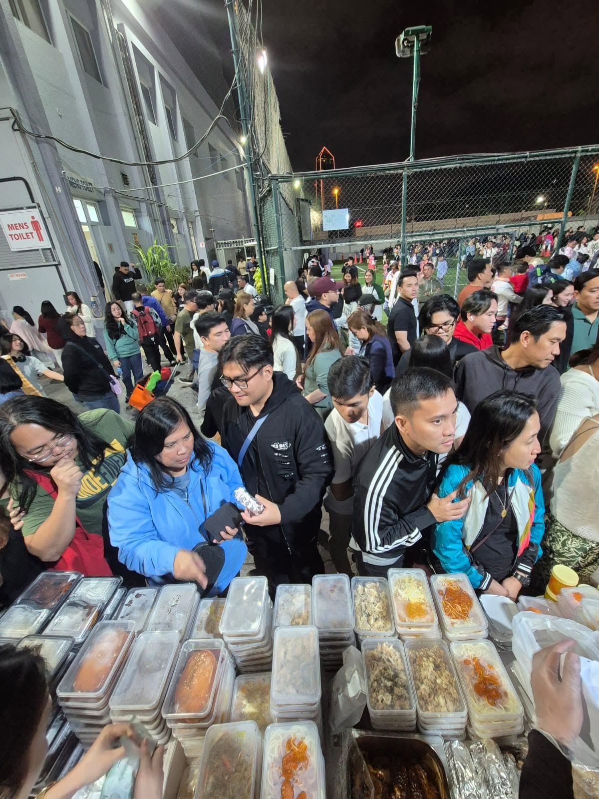 Long queue of community members waiting for free meals from Sweet Pepper